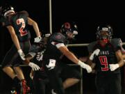 Dane Santos celebrates with his teammates after returning an interception for a 45-yard touchdown.