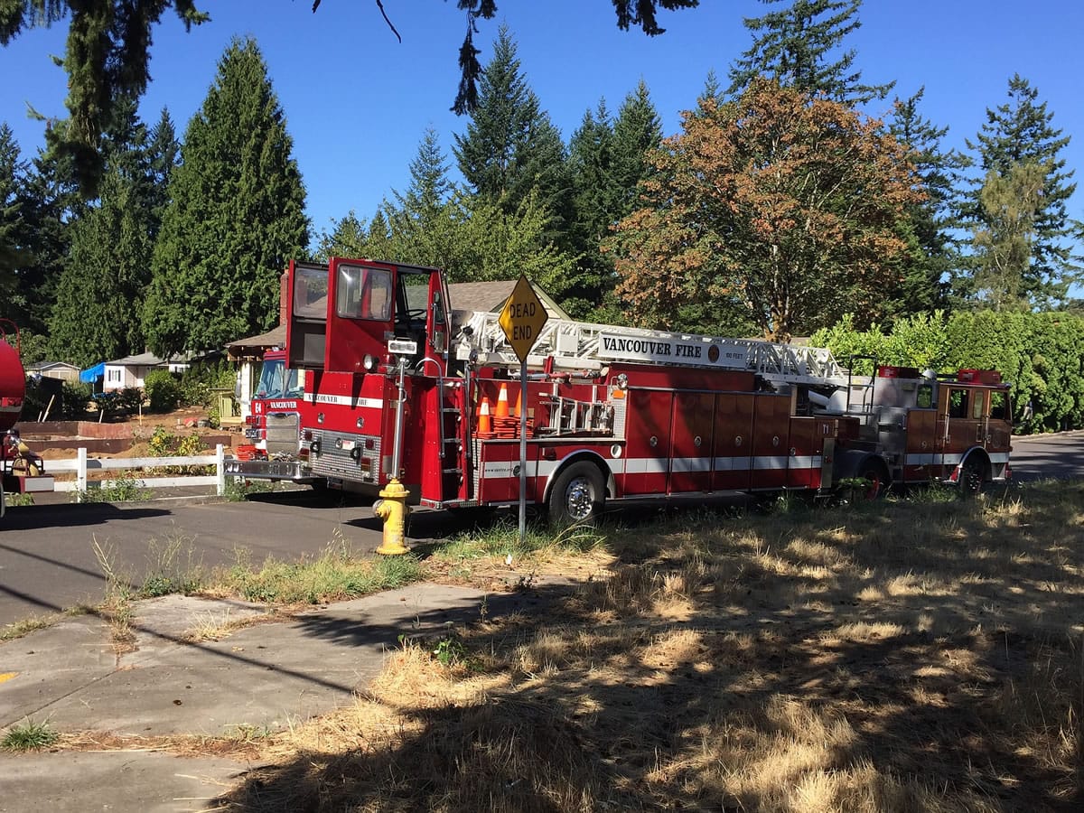 Firefighters respond to a brush fire that reportedly spread to a structure Tuesday afternoon near Northeast 11th Street and 106th Avenue in Vancouver.