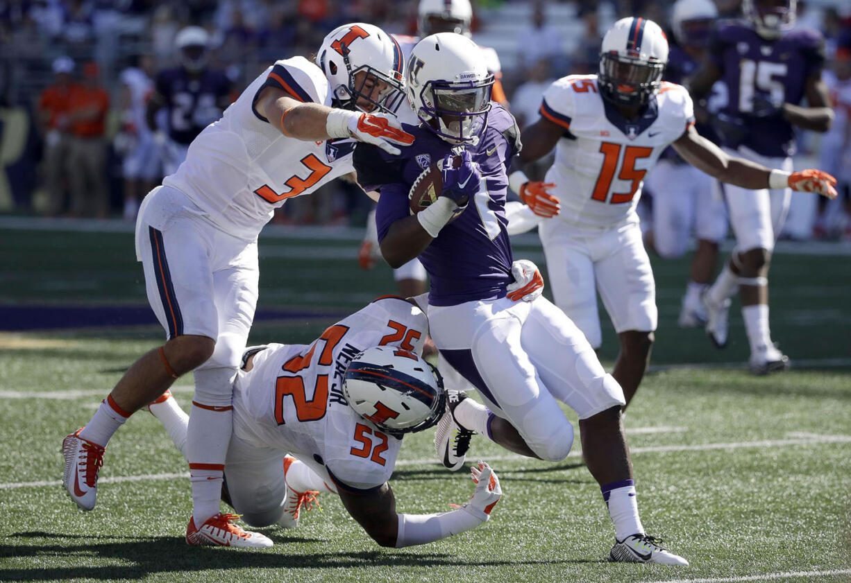 Washington wide receiver John Ross, center, is tackled by Illinois defensive back Taylor Barton (3) and linebacker T.J. Neal Jr. (52) in the first half Saturday, Sept. 13, 2014, in Seattle. (AP Photo/Ted S.