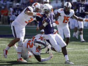 Washington wide receiver John Ross, center, is tackled by Illinois defensive back Taylor Barton (3) and linebacker T.J. Neal Jr. (52) in the first half Saturday, Sept. 13, 2014, in Seattle. (AP Photo/Ted S.