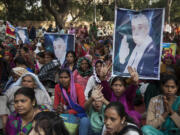 Supporters of controversial Indian guru Sant Rampal displaying his photographs, chant slogans praising him as they gather to show support at a protest venue near the Indian Parliament in New Delhi, India, on Tuesday.