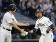 Seattle Mariners' Robinson Cano, right, is congratulated by Seth Smith after Cano's home run in the third inning Saturday, May 30, 2015, in Seattle.