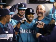 Seattle Mariners' Endy Chavez, center, is congratulated in the dugout after hitting a home run against the Cleveland Indians in the seventh inning of a baseball game Friday, June 27, 2014, in Seattle.