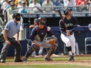 Seattle's Brad Miller watches his second home run alongside, Cleveland catcher Yan Gomes and umpire Mike DiMuro during Monday's spring training game at Peoria, Ariz.