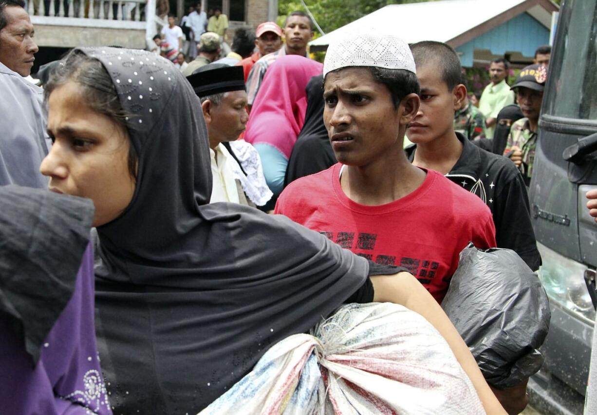 Ethnic Rohingya people whose boats were washed ashore on Sumatra island wait to be taken to a temporary shelter Sunday in Seunuddon, Indonesia.