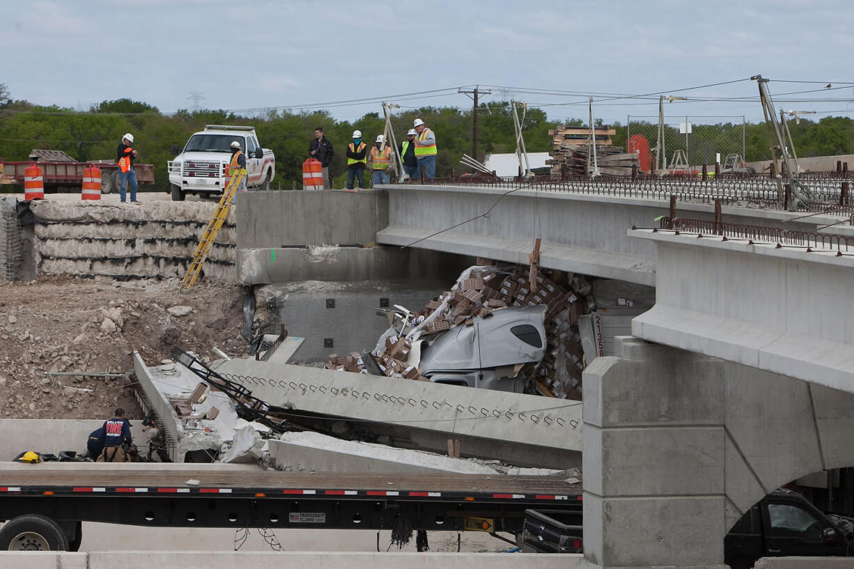 Authorities investigate a tractor-trailer that crashed into an overpass under construction on Thursday in Salado, Texas.