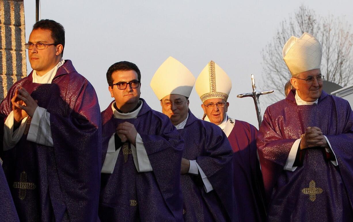 Pope Francis, second from right,  arrives to celebrate a mass on the occasion of a pastoral visit to the Santa Maria Madre del Redentore parish church on the outskirts of Rome, on Sunday.