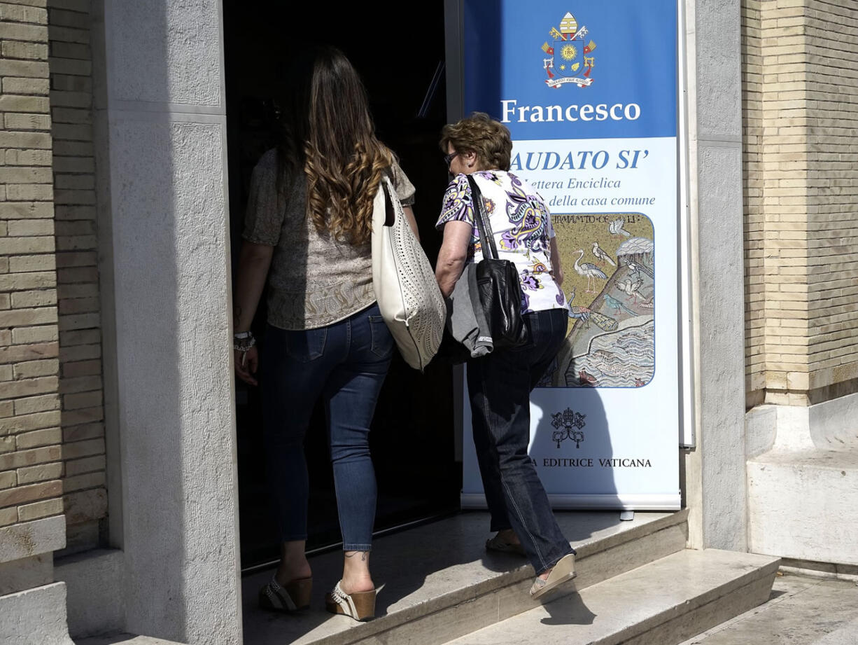 Two women walk into the Vatican bookshop where Pope Francis' encyclical in on sale in Rome on Thursday.