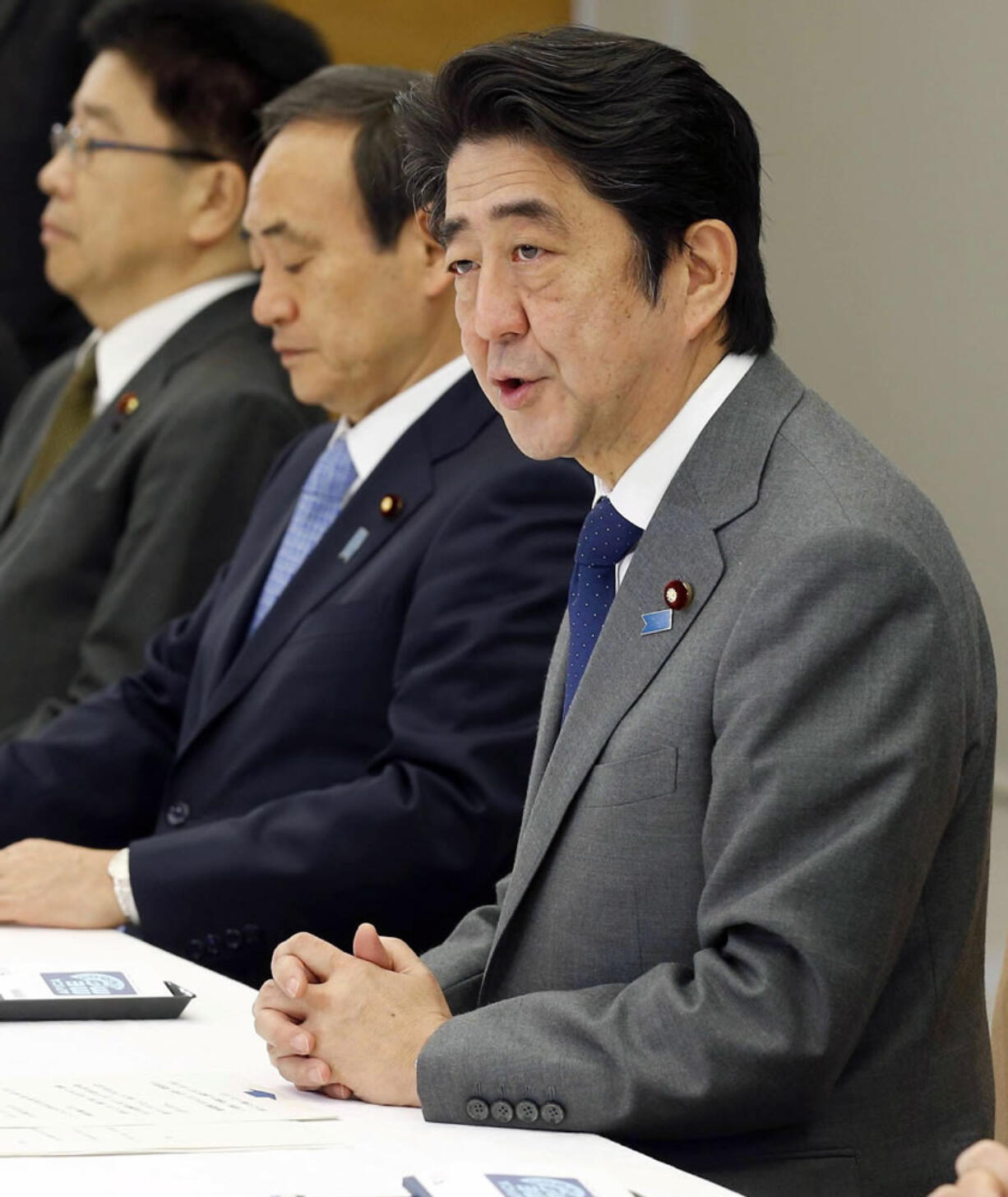 Japan's Prime Minister Shinzo Abe, right, speaks during a meeting on the hostage crisis, at his official residence in Tokyo Wednesday, Jan. 28, 2015. Japanese officials were tightlipped Wednesday as secret talks in Jordan sought to secure the freedom of a Japanese journalist and a Jordanian pilot captured by Islamic State extremists and purportedly threatened with death within 24 hours.