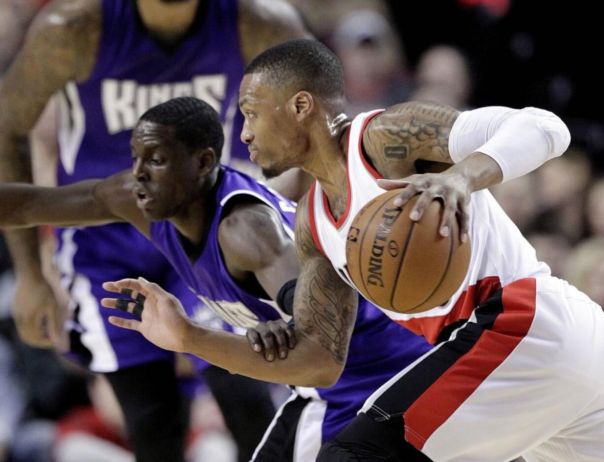 Portland Trail Blazers guard Damian Lillard, right, drives on Sacramento Kings guard Darren Collison during the first half Monday, Jan. 19, 2015.