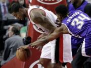 Sacramento Kings forward Jason Thompson, right, reaches in to knock the ball away from Portland Trail Blazers forward LaMarcus Aldridge during the first half Monday.