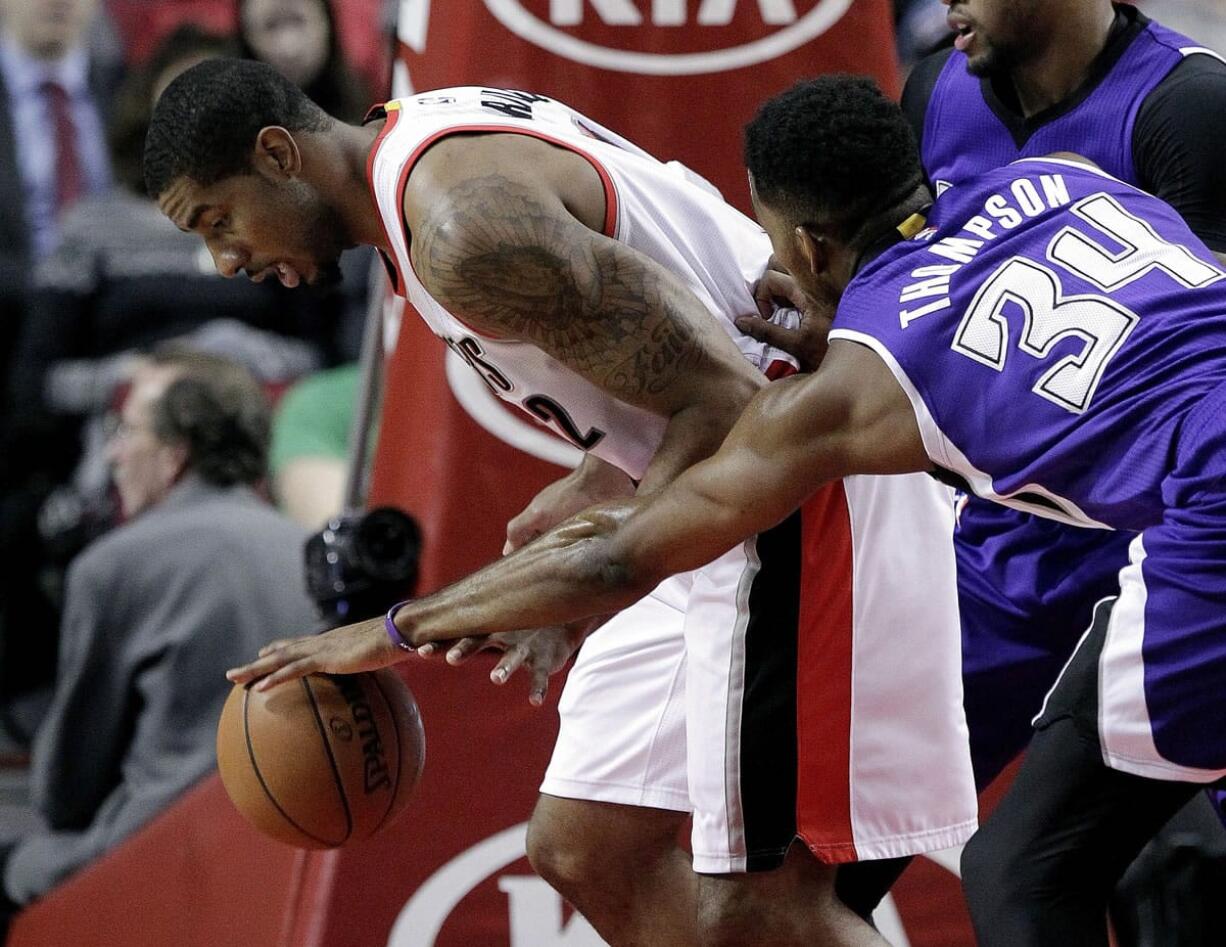 Sacramento Kings forward Jason Thompson, right, reaches in to knock the ball away from Portland Trail Blazers forward LaMarcus Aldridge during the first half Monday.