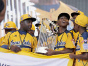 In this Aug. 27, 2014, file photo, members of the Jackie Robinson West Little League baseball team participate in a rally in Chicago celebrating the team's U.S. Little League Championship. Little League International has stripped Chicago's Jackie Robinson West team of its national title after finding the team falsified its boundary map. The league made the announcement Wednesday morning, Feb. 11, 2015, saying the Chicago team violated regulations by placing players on the team who didn?t qualify because they lived outside the team?s boundaries.