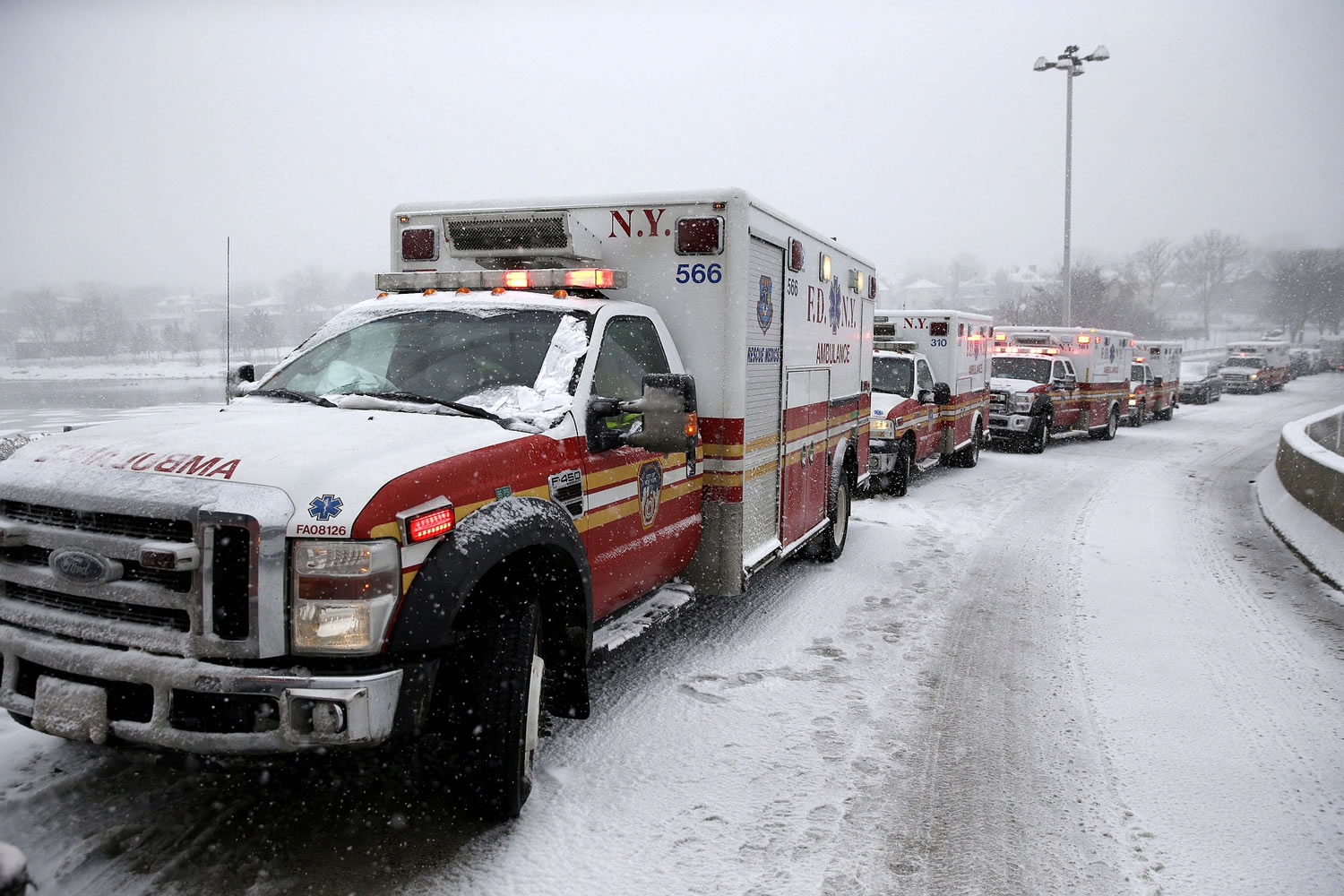 Emergency vehicles line up outside of a terminal at LaGuardia Airport in New York, Thursday, March 5, 2015. A plane from Atlanta skidded off a runway at the airport while landing Thursday, crashing through a chain-link fence.