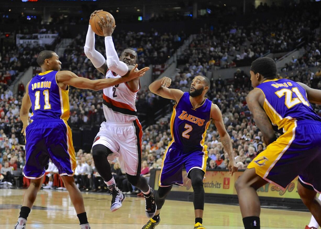 Portland Trail Blazers' Wesley Matthews (2) drives against Los Angeles Lakers' Wesley Johnson (11) and Wayne Ellington (2) during the second half of an NBA basketball game in Portland, Ore., Wednesday, Feb. 11, 2015. Matthews had a team-high 20 points as the Trail Blazers won 102-86.