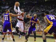 Portland Trail Blazers' Wesley Matthews (2) drives against Los Angeles Lakers' Wesley Johnson (11) and Wayne Ellington (2) during the second half of an NBA basketball game in Portland, Ore., Wednesday, Feb. 11, 2015. Matthews had a team-high 20 points as the Trail Blazers won 102-86.