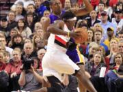 Portland's Gerald Wallace drives on Lakers forward Metta World Peace during the first half Thursday.