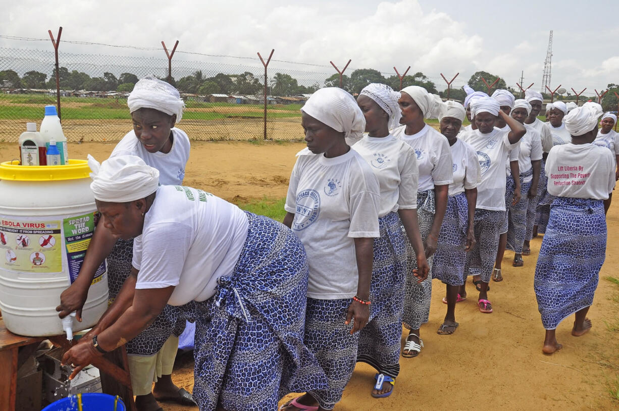 Women from different religious groups wash their hands after praying to prevent the spread of the Ebola virus Saturday in Monrovia, Liberia.