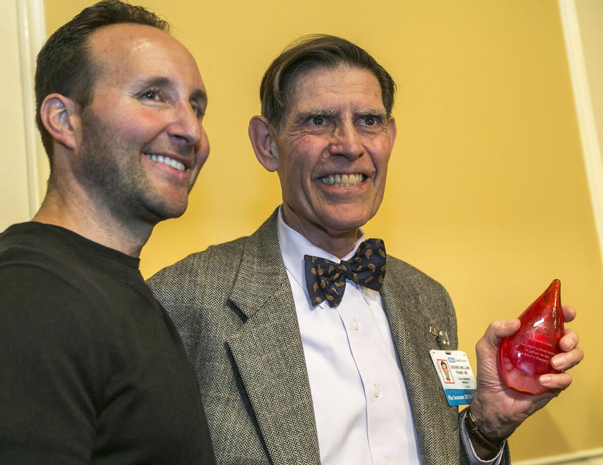 Motorcycle crash victim Brandon Levine, left, presents UCLA's Dr. Gerard Frank with the UCLA Blood and Platelet Center's twenty-four-gallon donor award at the UCLA campus in Los Angeles on Friday, Jan. 30, 2015. Dr. Frank is part of the center's pool of donors of the 207 units of blood, plasma and platelets that preserved Levine's life after a devastating motorcycle accident on April 27, 2014, that left him comatose for a month, during a ceremony. Levine is still recovering from his injuries but he says &quot;as soon as they give me the green light&quot; he's going to become a blood donor too.