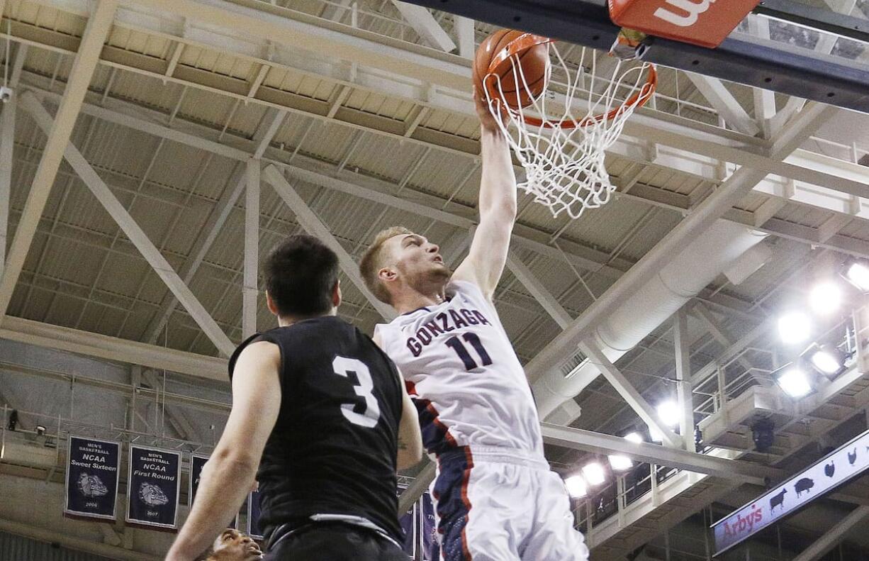 Gonzaga's Domantas Sabonis (11) dunks against Loyola Marymount's Casey Norris (3) during the second half Thursday, Feb. 12, 2015, in Spokane. Gonzaga won 80-51.