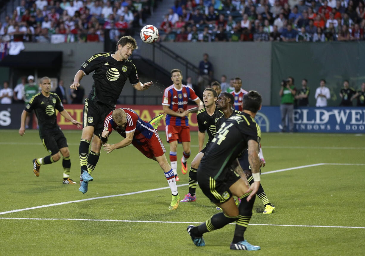 D.C. United defender Bobby Boswell heads the ball in an attempt to clear it near the goal as Bayern Munich's Sebastian Rode dives to stop him in the second half of the MLS All-Star soccer game, Wednesday, Aug. 6, 2014, in Portland, Ore. The MLS All-Stars won 2-1. (AP Photo/Ted S.