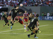 D.C. United defender Bobby Boswell heads the ball in an attempt to clear it near the goal as Bayern Munich's Sebastian Rode dives to stop him in the second half of the MLS All-Star soccer game, Wednesday, Aug. 6, 2014, in Portland, Ore. The MLS All-Stars won 2-1. (AP Photo/Ted S.