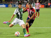 Portland Timbers midfielder Diego Valeri, left, puts a shot on goal as Chivas USA defender Donny Toia closes in during the second half Saturday, Aug.