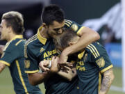 Portland Timbers forward Gaston Fernandez, right, is hugged by Norberto Paparatto after Fernandez scored on a penalty kick Saturday against the Houston Dynamo.