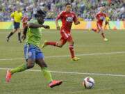 Seattle Sounders' Obafemi Martins, left, wearing a protective mask, goes in for a shot against FC Dallas during the second half Saturday, June 13, 2015, in Seattle. The Sounders won 3-0. (AP Photo/Ted S.