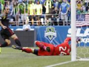 Los Angeles Galaxy's Landon Donovan, left, scores a goal on Seattle Sounders goalkeeper Stefan Frei, right, in the first half Monday, July 28, 2014, in Seattle. (AP Photo/Ted S.