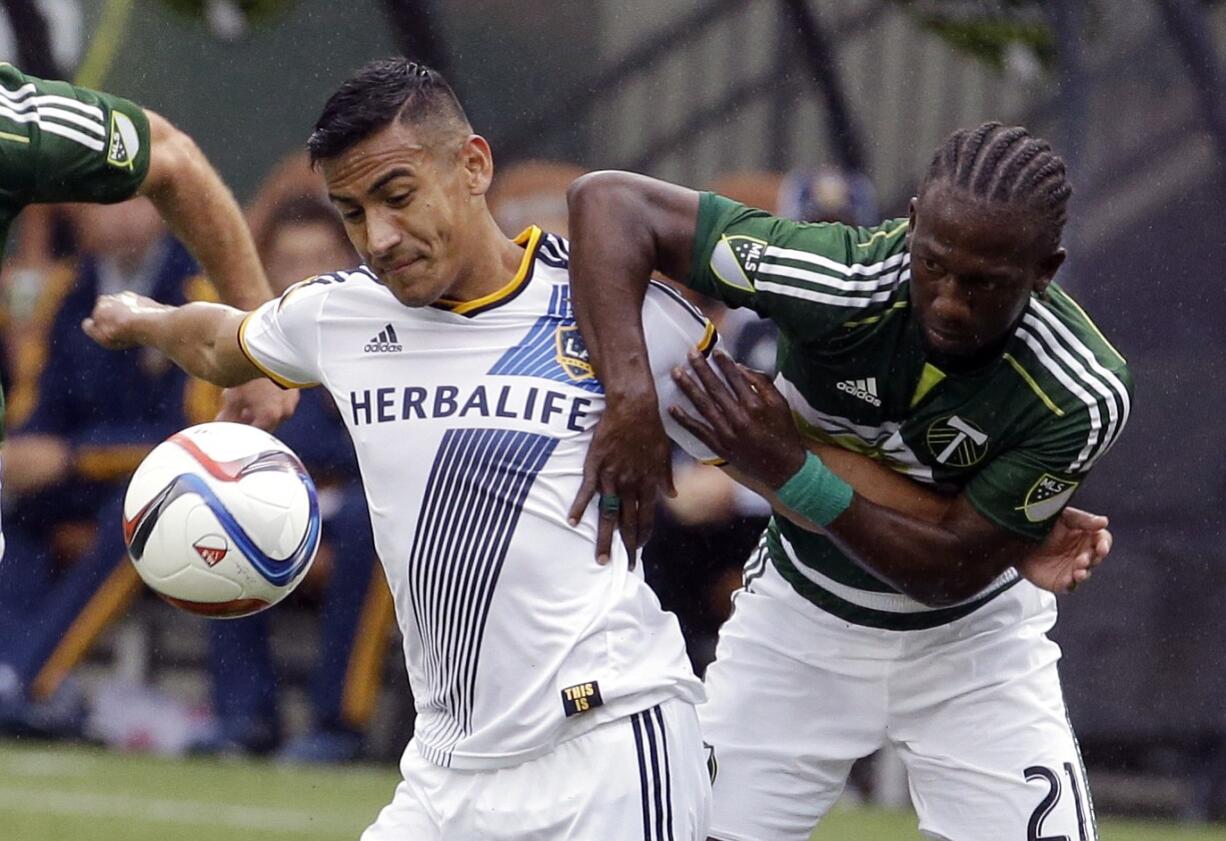 Los Angeles Galaxy forward Jose Villarreal, left, and Portland Timbers midfielder Diego Chara battle for the ball during the first half of an MLS soccer game in Portland, Ore., Sunday, March 15, 2015.