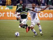 Portland Timbers forward Darlington Nagbe, left, chases down the ball against Los Angeles Galaxy midfielder Juninho during the first half of an MLS soccer game in Portland, Ore., Sunday, March 15, 2015.