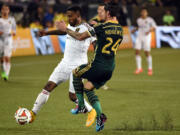 Real Salt Lake forward Robbie Findley,left, and Portland Timbers defender Liam Ridgewell (24) battle for a ball during the first half Friday, Oct. 17, 2014, in Portland.