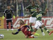 Kyle Beckerman, lower left, of Real Salt Lake, slide tackles Darlington Nagbe, right, of the Portland Timbers, during the first half Saturday, March 7, 2015, in Portland.