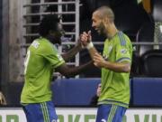 Seattle Sounders' Obafemi Martins, left is greeted by Clint Dempsey, right, after Martins scored a goal against the New England Revolution in the first half Sunday, March 8, 2015, in Seattle. Dempsey also scored in the first half of the match. (AP Photo/Ted S.