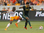 Portland Timbers midfielder Rodney Wallace, right, dribbles past Houston Dynamo midfielder Boniek Garcia, left, in the first half Saturday, May 16, 2015, in Houston.