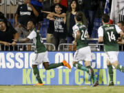 Portland Timbers' Rodney Wallace, left, celebrates with teammates Ben Zemanski (14) and Liam Ridgewell (24) after scoring a goal against the San Jose Earthquakes during the second half in Santa Clara, Calif., Saturday, Oct. 4, 2014. Portland won 2-1.