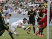 Los Angeles Galaxy's Robbie Keane, center, scores against Portland Timbers goalkeeper Donovan Ricketts during the second half Saturday, Aug. 2, 2014, in Carson, Calif. The Galaxy won 3-1. (AP Photo/Jae C.