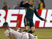 Los Angeles Galaxy defender Omar Gonzalez, left, tackles the ball away from Portland Timbers defender Jorge Villafana during the first half Wednesday.