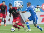 Montreal Impact's Andres Romero, right, challenges Portland Timbers' Liam Ridgewell during the first half of a soccer game, Saturday, May 9, 2015 in Montreal.