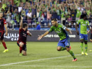 Seattle Sounders' Clint Dempsey, center, celebrates after scoring a goal against the Portland Timbers, in the second half of an MLS soccer match, Sunday, July 13, 2014, in Seattle. (AP Photo/Ted S.