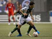 Portland Timbers' Diego Valeri, front, of Argentina, controls the ball as Vancouver Whitecaps' Russell Teibert defends during the first half of an MLS soccer game in Vancouver, British Columbia, on Saturday, Aug. 30, 2014.