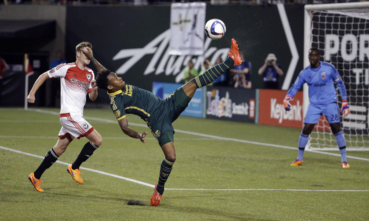 Portland Timbers forward Rodney Wallace, middle, stretches high for the ball as D.C. United goalkeeper Bill Hamid, right, and defender Taylor Kemp watch during the second half of an MLS soccer game in Portland, Ore., Wednesday, May 27, 2015. Portland won 1-0.