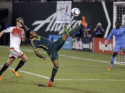 Portland Timbers forward Rodney Wallace, middle, stretches high for the ball as D.C. United goalkeeper Bill Hamid, right, and defender Taylor Kemp watch during the second half of an MLS soccer game in Portland, Ore., Wednesday, May 27, 2015. Portland won 1-0.