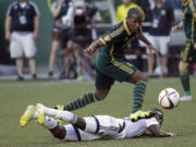 Portland Timbers forward Darlington Nagbe, top, leaps over Vancouver Whitecaps midfielder Gershon Koffie as he chases the ball during the first half of an MLS soccer game in Portland, Ore., Saturday, July 18, 2015.