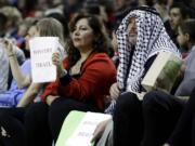 Hala Gores, left, and Joe Finkbonner hold &quot;Boycott Israel&quot; signs from their courtside seats during the Trail Blazers' exhibition game against Maccabi Haifa.