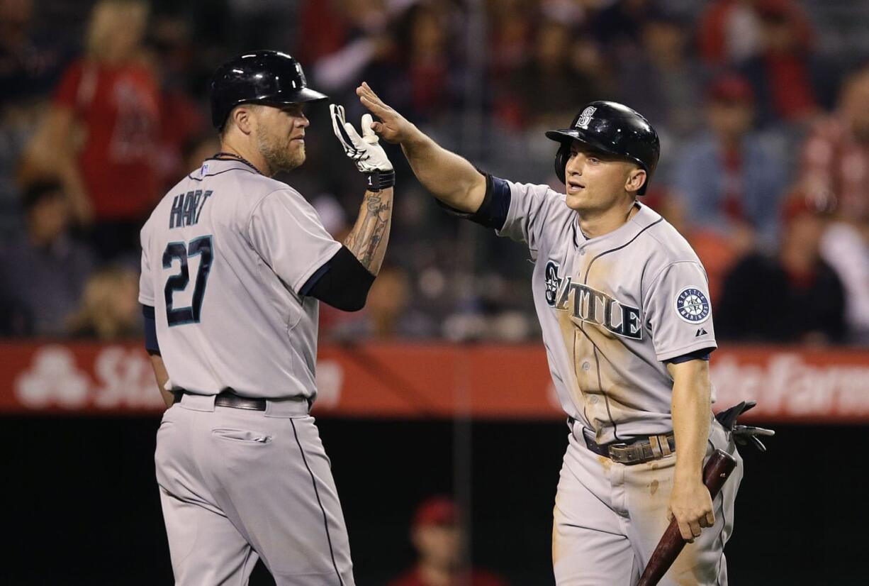 Seattle Mariners' Kyle Seager, right, is greeted by Corey Hart after he scored on a double hit by Logan Morrison during the 12th inning Saturday. (AP Photo/Jae C.