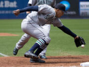 Seattle Mariners starting pitcher Taijuan Walker bobbles the ball but manages to recover and force out Toronto Blue Jays shortstop Ryan Goins at first base during the third inning Sunday, May 24, 2015, in Toronto.