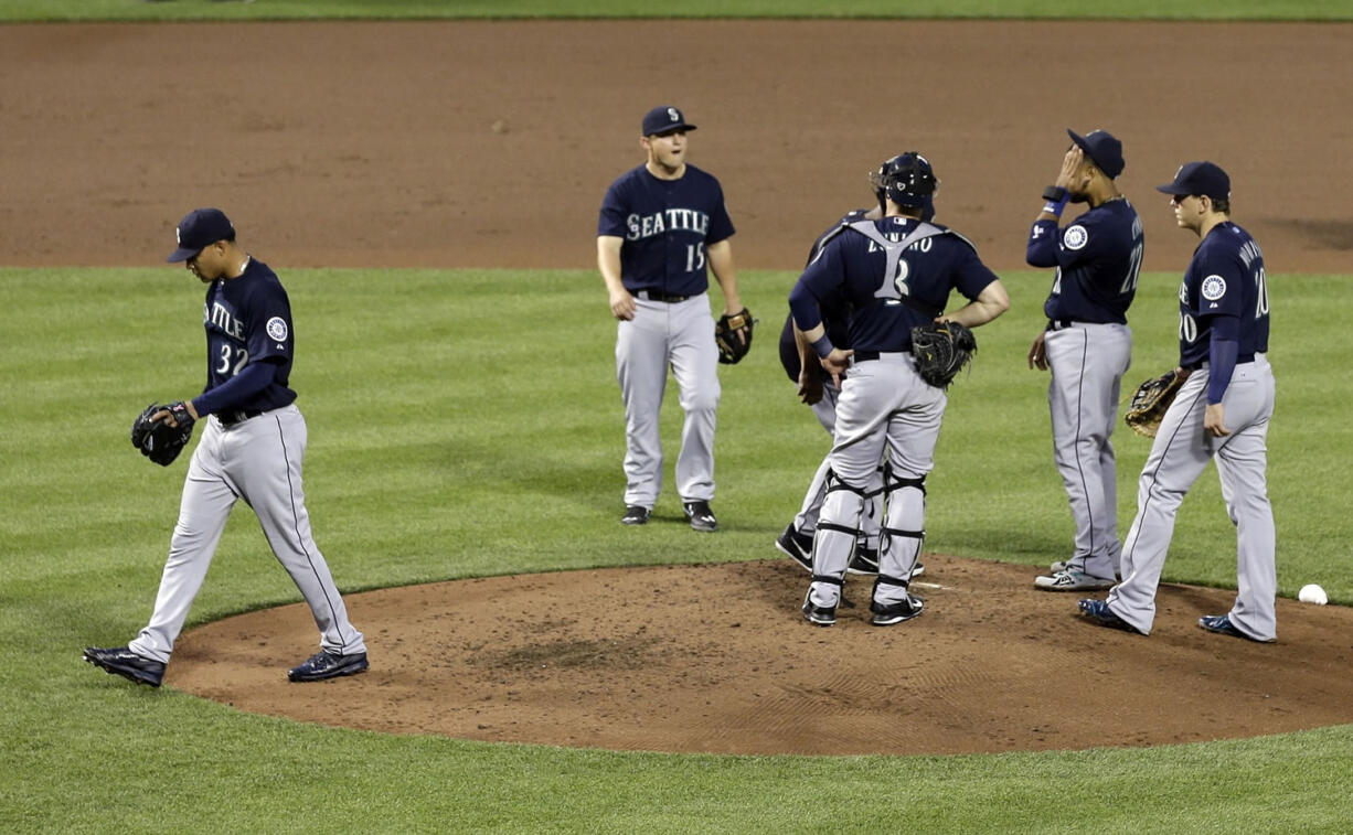 Seattle Mariners starting pitcher Taijuan Walker, left, walks off the field after being relieved in the fourth inning of a baseball game against the Baltimore Orioles, Tuesday, May 19, 2015, in Baltimore. Baltimore won 9-4.