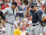 Seattle Mariners starting pitcher Felix Hernandez, left, and catcher Mike Zunino stand on the mound after giving up a run to the Boston Red Sox during the third inning of a baseball game at Fenway Park in Boston Saturday, Aug.